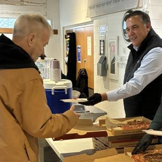 Ginther handing food to man