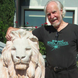 Jim Heddle standing next to a lion statue