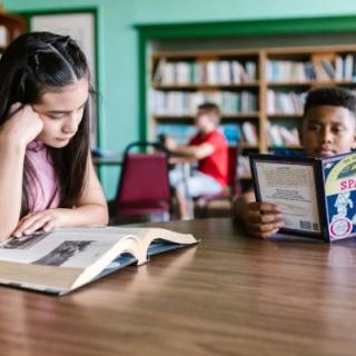 Kids reading at table in library