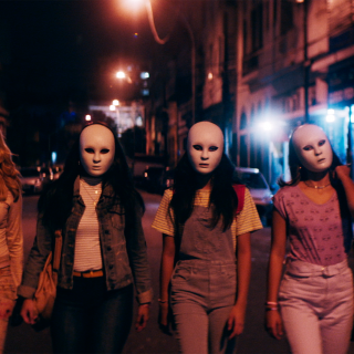 Women walking at night wearing masks