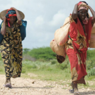 Immigrant women walking on dirt path in Africa