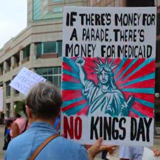 Protester holding sign saying If there's money for a parade there's money for Medicaid