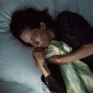 Woman lying in bed looking scared