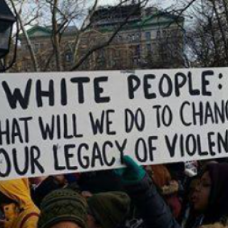Banner saying White People What will we do to change our legacy of violence