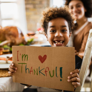 Little boy holding sign I'm Thankful