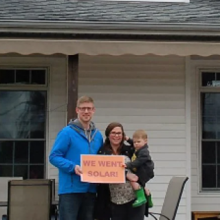 Family holding a sign saying We Went Solar