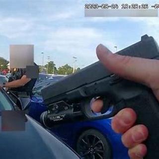 Hand holding a gun at a car