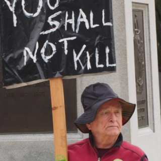 Protester with sign saying You Shall Not Kill