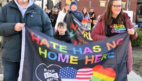 People marching with banner saying Hate has no home here