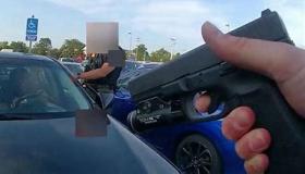 Hand holding a gun at a car