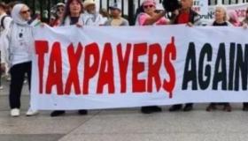People holding Taxpayers Aganst Genocide banner